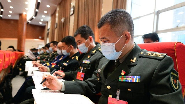 参会的解放军代表认真听取工作报告