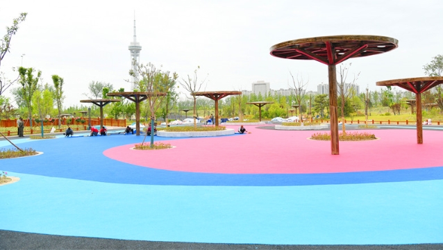 周口沙颍河湿地公园内游乐场所正在铺塑胶地面