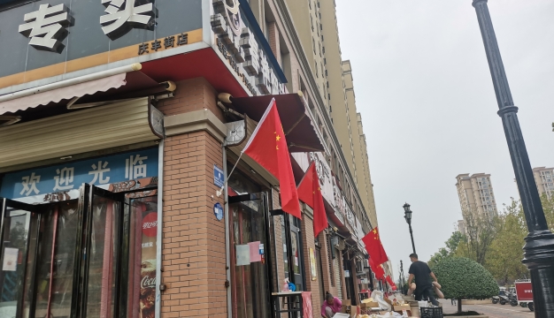 城区街头国旗飘 同贺国庆氛围浓