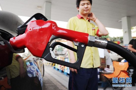 毛七/5月9日，重庆江北区一中石油加油站工作人员在为顾客加油。