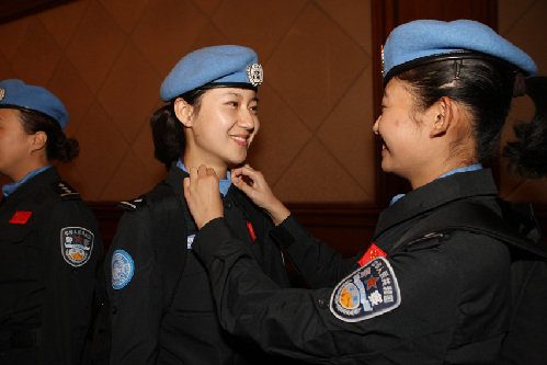 10月21日，两名女维和警察在出发前互相整理服装。新华社发（刘长龙 摄）