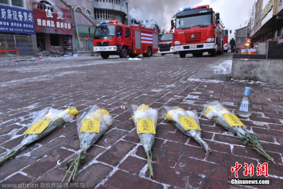 担心再次塌方 哈尔滨消防员楼外打水救援-中华